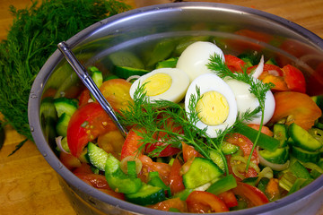 Fresh vegetables and egg salad in steel bowl