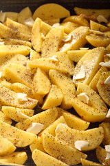Raw potatoes with spices ready to be roasted as background