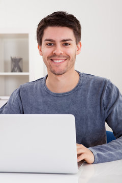 Smiling young man using a laptop