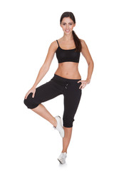 Fototapeta na wymiar Young Woman Exercising While Standing On One Leg