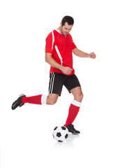 Professional soccer player kicking ball
