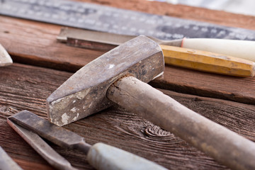 Dirty set of hand tools on a wooden panel