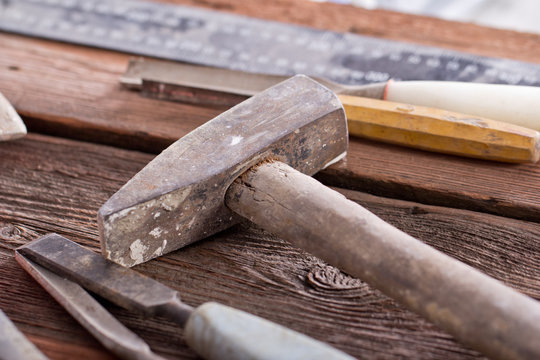 Dirty set of hand tools on a wooden panel