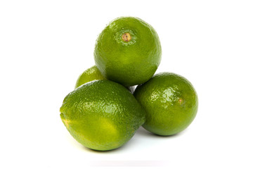 Group of whole limes  and one half lime on white