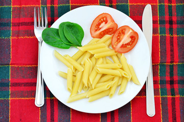 Pasta, tomatoes and spinach on the plate