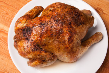 roast chicken on white plate and wooden