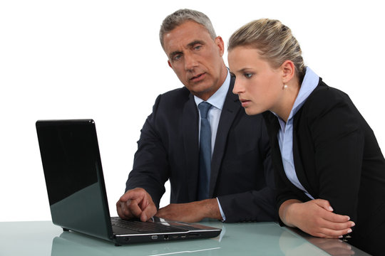 businessman and businesswoman analysing data on their laptop