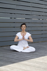 young woman practising the lotus position outdoors