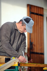 Man marking plank before cutting it