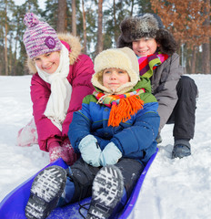 Fototapeta premium Children on sleds in snow