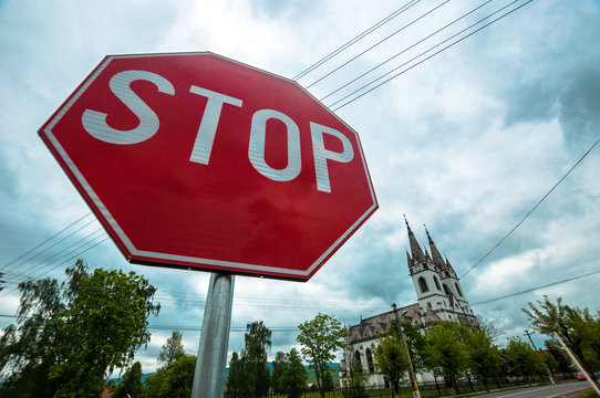 Red Stop Sign With Church In The Background