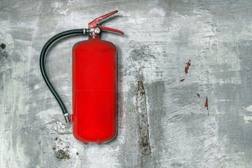 Red fire extinguisher on concrete wall