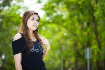 Fototapeta premium Portrait of young beautiful woman against summer garden