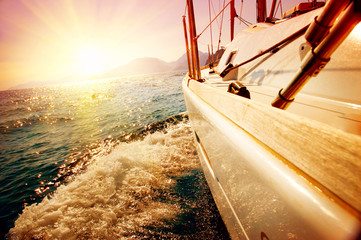 Yacht Sailing against sunset. Sailboat. Yachting. Sailing - obrazy, fototapety, plakaty