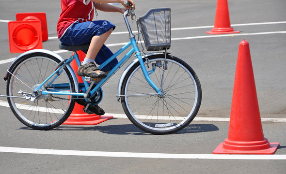 Ecolier &agrave; v&eacute;lo sur un circuit avec des plots oranges, apprentissage du code de la route, exercice de pr&eacute;vention routi&egrave;re enfants	