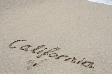 Conceptual handwritten text California in sand