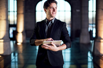Homme d'affaire souriant avec une tablette