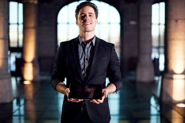 Homme souriant montrant une tablette tactile