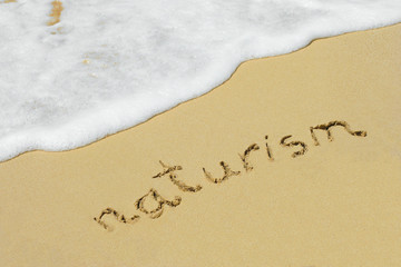 Fototapeta premium Naturism handwritten in sand