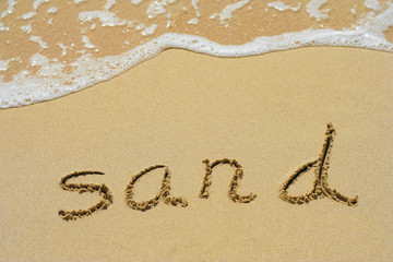 Conceptual hand made or handwritten sand text in sand