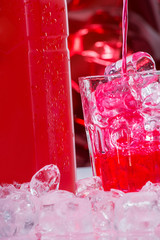 Red drink with bottle of vodka