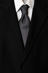 Close up of businessman wearing a tie, shirt, and suit.