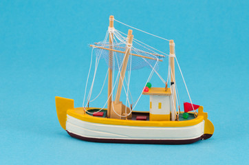 wooden handmade boat ship model on blue background