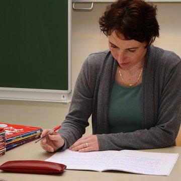Lehrerin verbessert Hefte