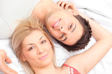Close-up shot of a young couple laying in a bed