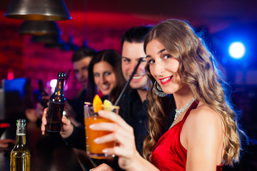 People with cocktails in bar or club