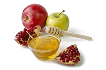 Apples, pomegranate and bowl of honey