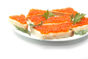 Red caviar on bread on white plate close-up
