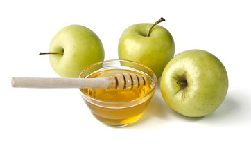 Green apples and a bowl of honey