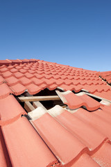 Damaged red tile roof construction house