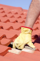 Construction worker tile roofing repair
