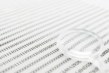 Fototapeta premium Binary code and magnifying glass