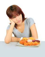 Isolated young asian woman with a donuts on the table