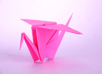 Origami crane on purple background.