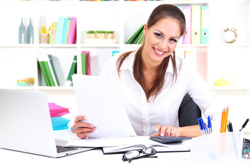Young pretty business woman with notebook in office