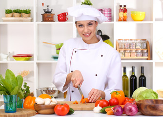 Young woman chef cooking in kitchen