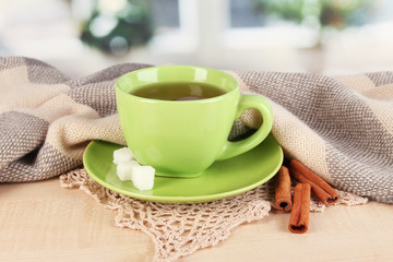 cup of tea with scarf on table in room