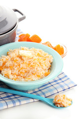 Taste rice porridge with pumpkin in blue bowl, isolated