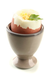 Boiled egg in egg cup, isolated on white