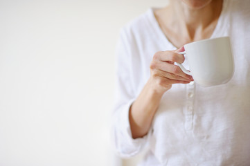 Woman hand with white cup on white background