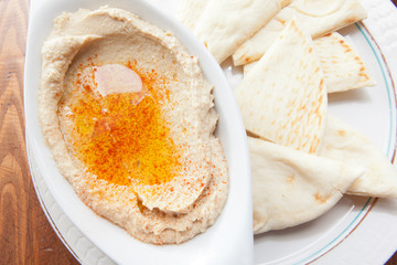 Creamy hummus topped with olive oil served with pita bread