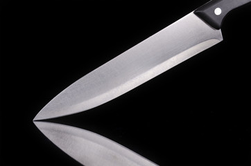 Close up view of a kitchen knife over black isolated