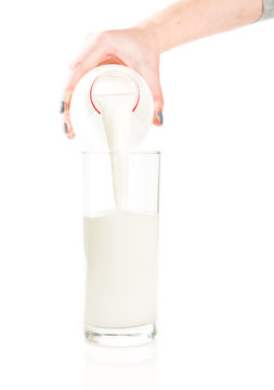 Pouring fresh white milk from bottle into a glass