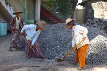 Women shoveling sand, women working in construction in Myanmar