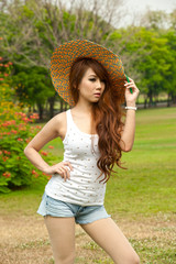 Pretty Asian woman in posing with hat .