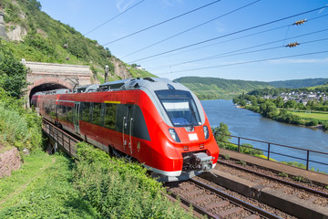 Fototapeta premium Pociąg Intercity opuszczający tunel w pobliżu rzeki Mozeli w Niemczech